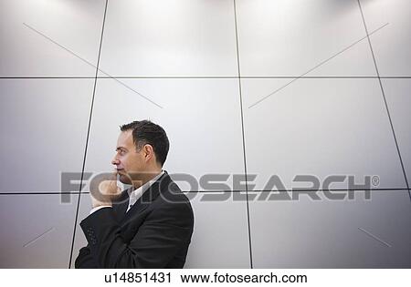 Stock Image - Businessman against grid wall. Fotosearch