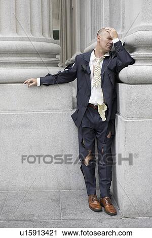 Stock Image - "Businessman wearing torn clothing outside office building, San Francisco, California, USA". Fotosearch