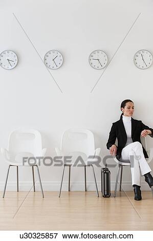 Businesswoman looking at wrist watch in waiting room View Large Photo Image Stock Photo - Businesswoman looking at wrist watch in waiting room. Fotosearch