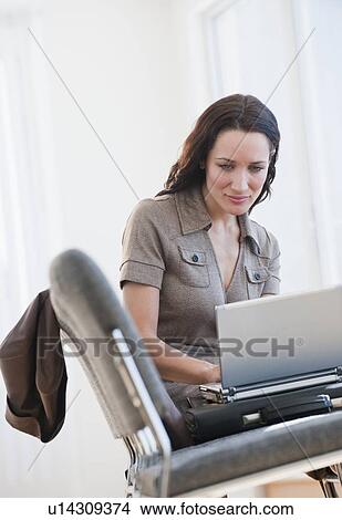 Businesswoman using laptop in waiting room View Large Photo Image Picture - Businesswoman using laptop in waiting room. Fotosearch