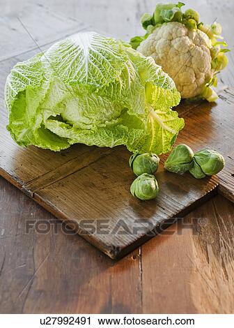 Stock Image - "Cauliflower, cabbage and brussel sprouts on wooden table". Fotosearch