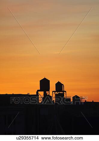 Picture - "Cityscape with silhouettes of water towers at sunset, New York City, New York, USA". Fotosearch