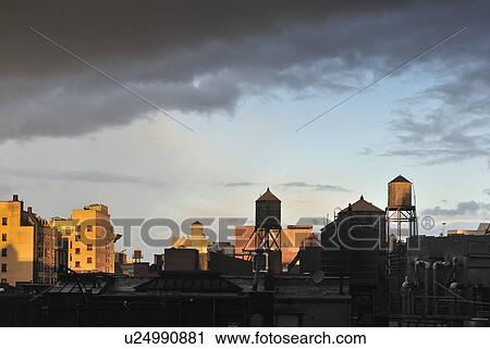 Stock Image - "Cityscape with water towers at sunset, New York City, New York, USA". Fotosearch