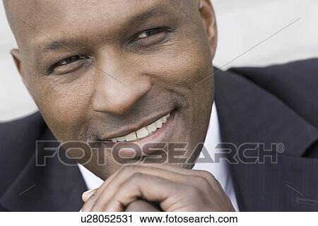 "Close-up of businessman smiling, studio shot" View Large Photo Image Stock Image - "Close-up of businessman smiling, studio shot". Fotosearch