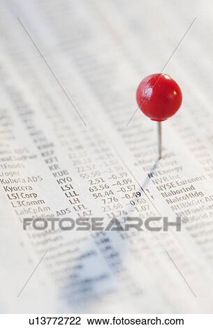 Stock Image - Close-up of pin on stock market newspaper. Fotosearch