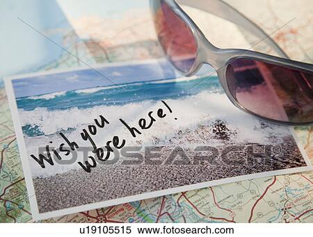 Stock Photography - Close-up of sunglasses and postcard on map. Fotosearch