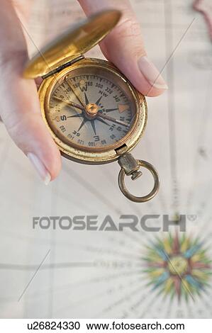 Stock Image - Close-up of woman holding antique compass. Fotosearch