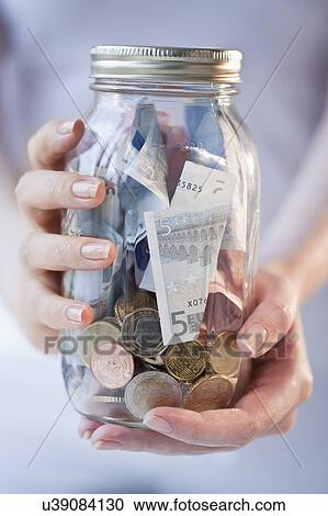 Close-up of woman holding jar of money View Large Photo Image Stock Image - Close-up of woman holding jar of money. Fotosearch
