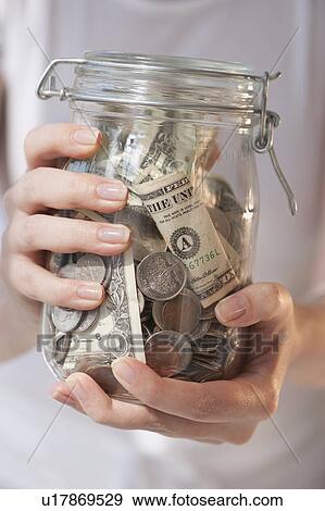 Close-up of woman holding jar of money View Large Photo Image Stock Photo - Close-up of woman holding jar of money. Fotosearch