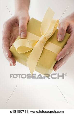 Close-up of woman holding present View Large Photo Image Stock Image - Close-up of woman holding present. Fotosearch