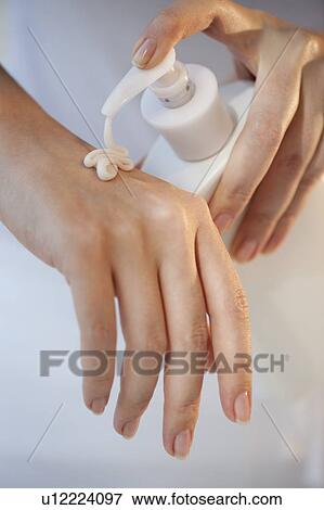 Close-up of woman using hand moisturizer View Large Photo Image Stock Photo - Close-up of woman using hand moisturizer. Fotosearch