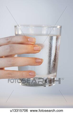 Close-up of woman's hand holding glass of water View Large Photo Image Stock Photograph - Close-up of woman's hand holding glass of water. Fotosearch