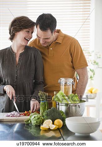 Picture - Couple preparing food in kitchen. Fotosearch