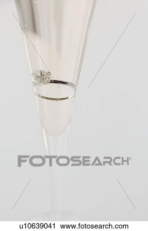 Stock Image - Engagement ring in champagne glass. Fotosearch