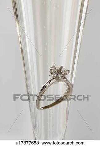 Stock Photo - Engagement ring in champagne glass. Fotosearch