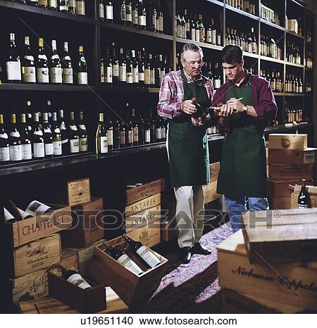 Stock Image - Father and son in liquor store. Fotosearch