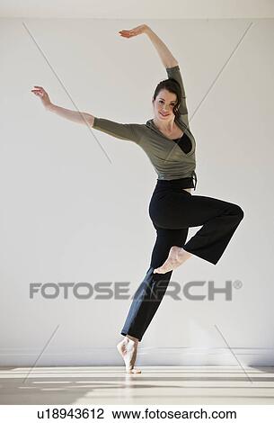 Stock Image - "Female ballet dancer jumping, studio shot". Fotosearch