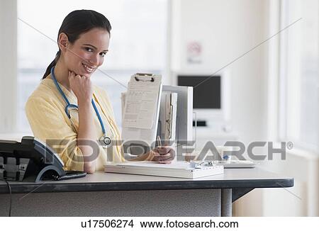 Female nurse at desk View Large Photo Image Picture - Female nurse at desk. Fotosearch