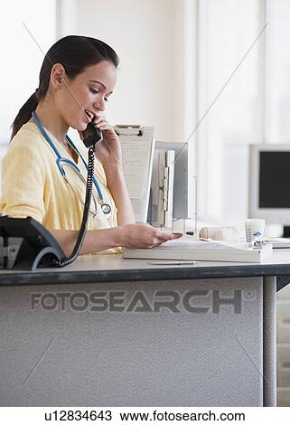 Female nurse talking on phone View Large Photo Image Stock Image - Female nurse talking on phone. Fotosearch