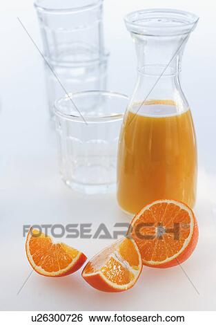 Stock Photograph - "Fresh orange juice in decanter with oranges slices, studio shot". Fotosearch