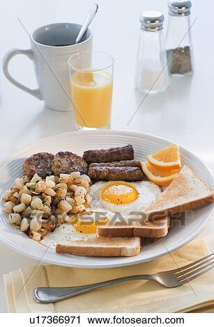 Fried sausages on plate with eggs and plates in background View Large Photo Image Stock Image - Fried sausages on plate with eggs and plates in background. Fotosearch