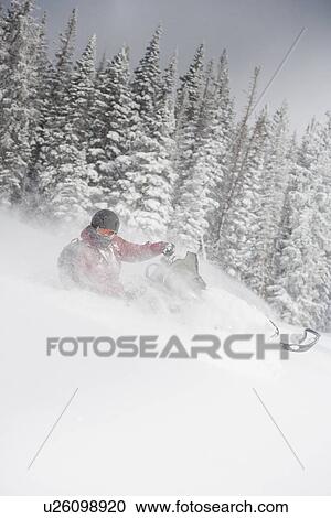 Stock Image - "Man driving snowmobile Aspen, Colorado, USA". Fotosearch