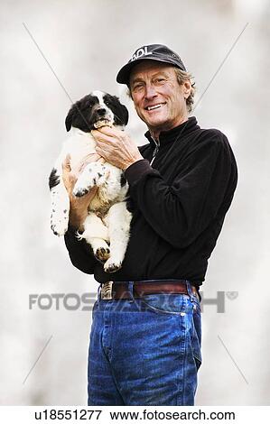 Man holding puppy View Large Photo Image Stock Photo - Man holding puppy. Fotosearch
