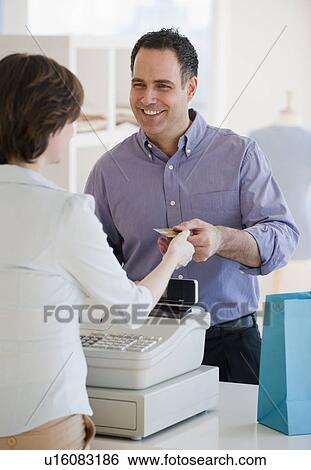 Stock Photograph - Man paying in store. Fotosearch