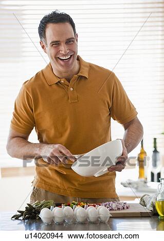 Picture - Man preparing food in kitchen. Fotosearch