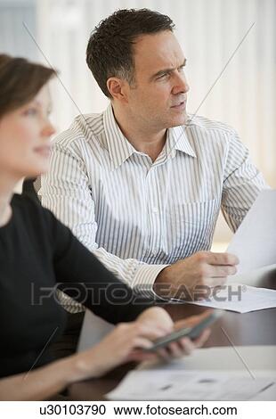 Stock Image - Mature businessman and businesswoman on business meeting. Fotosearch