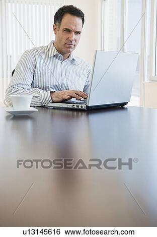 Mature businessman using laptop View Large Photo Image Stock Photograph - Mature businessman using laptop. Fotosearch