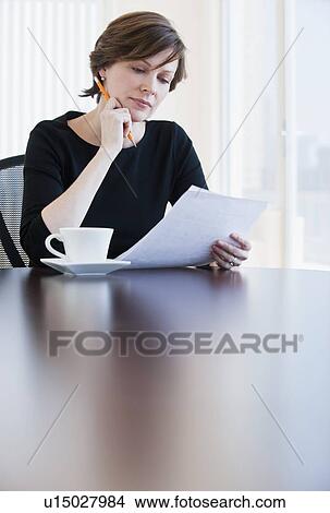 Picture - Mature businesswoman reading document. Fotosearch