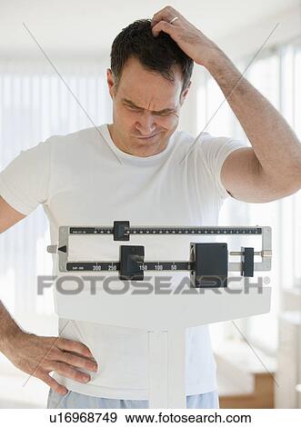 Mature man on scales View Large Photo Image Stock Photo - Mature man on scales. Fotosearch