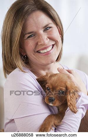Stock Photo - Mature woman hugging puppy. Fotosearch