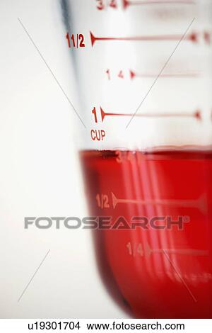 "Measuring jug filled with red liquid, close-up" View Large Photo Image Picture - "Measuring jug filled with red liquid, close-up". Fotosearch