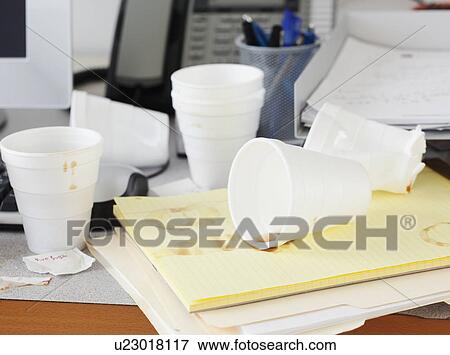 Stock Photo - Messy office desk with empty disposable cups. Fotosearch