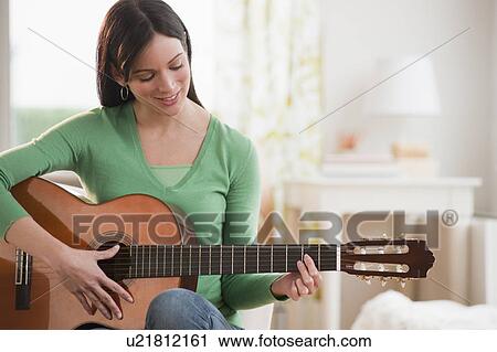 Mid-adult woman playing guitar View Large Photo Image Stock Image - Mid-adult woman playing guitar. Fotosearch