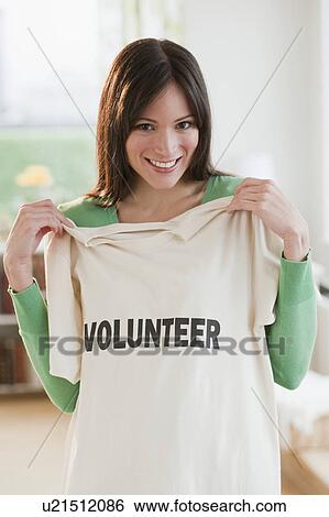 Stock Photograph - Mid-adult woman showing t-shirt reading Volunteer. Fotosearch