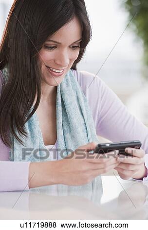 Mid-adult woman texting with mobile phone View Large Photo Image Stock Photo - Mid-adult woman texting with mobile phone. Fotosearch