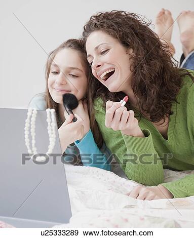 Stock Photo - Mother and daughter (10-12 years) doing make-up. Fotosearch