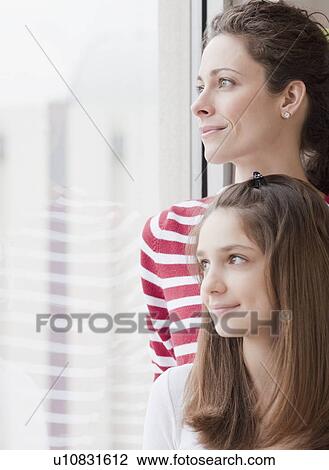 "Mother and daughter (10-12 years) looking through window, smiling" View Large Photo Image Stock Image - "Mother and daughter (10-12 years) looking through window, smiling". Fotosearch