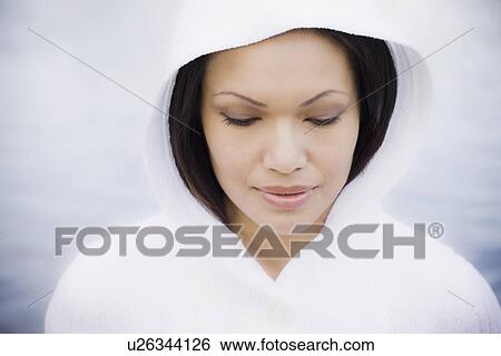 Stock Photograph - Pensive woman smiling by sea. Fotosearch