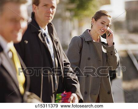 Stock Photo - People standing on railway platform waiting for train. Fotosearch