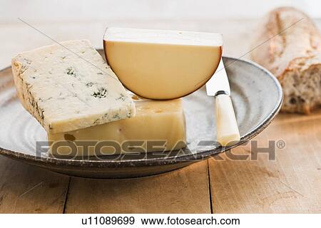 Stock Photo - Pieces of cheese with grapes on background. Fotosearch