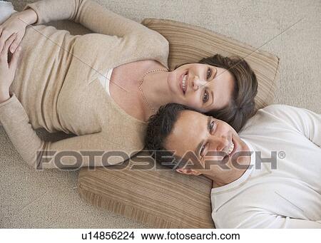 Picture - Portrait of couple lying on floor. Fotosearch
