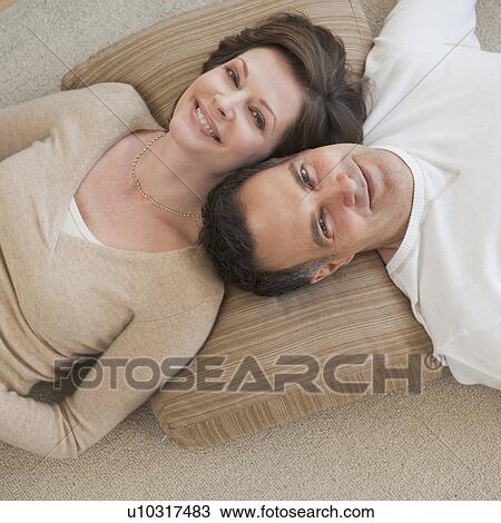 Stock Image - Portrait of couple lying on floor. Fotosearch