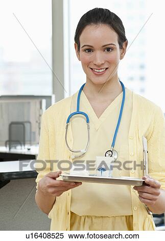 Stock Photography - Portrait of female nurse with clipboard. Fotosearch