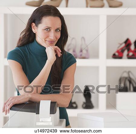 Portrait of female shoe shop owner by cash register View Large Photo Image Stock Photo - Portrait of female shoe shop owner by cash register. Fotosearch