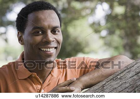 Stock Photograph - Portrait of man smiling in park. Fotosearch