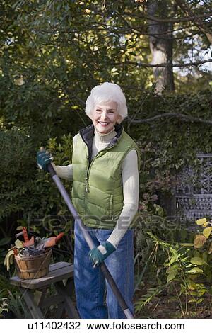 Stock Image - Portrait of senior woman gardening. Fotosearch